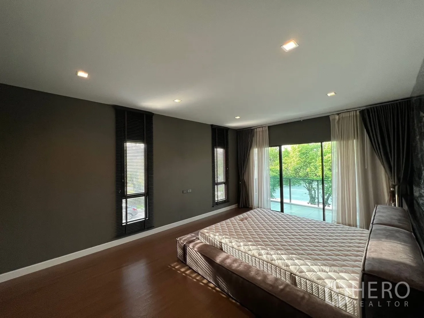 บ้าน ให้เช่าในBang Phli, Samut Prakan - ห้องนอนมาสเตอร์กว้าง พื้นไม้ หน้าต่างบานใหญ่ และประตูกระจกออกระเบียงมองสวน