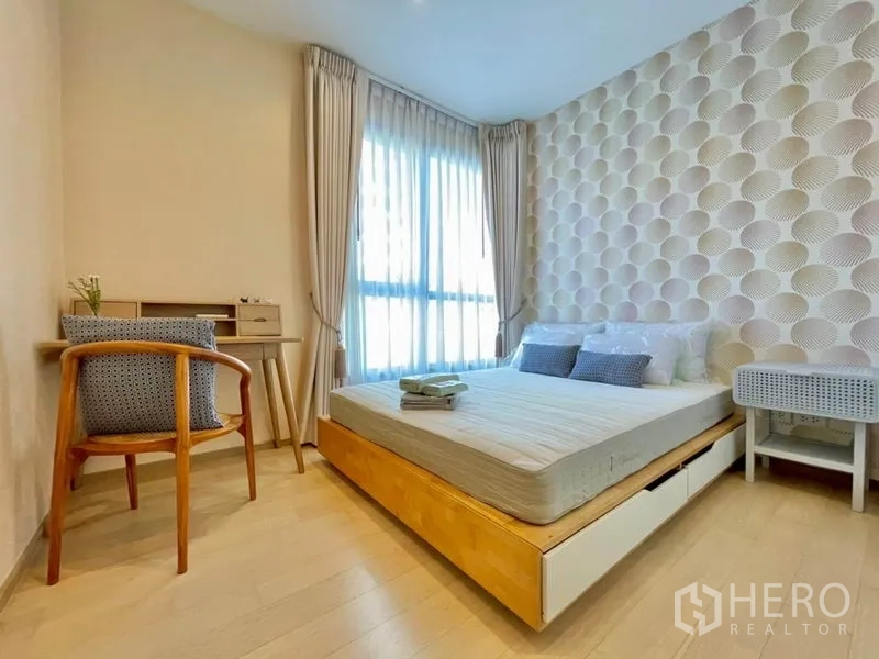Condominium for rent or sale in Watthana, Bangkok - Second bedroom with study desk, storage‑drawer bed and sheer curtains.