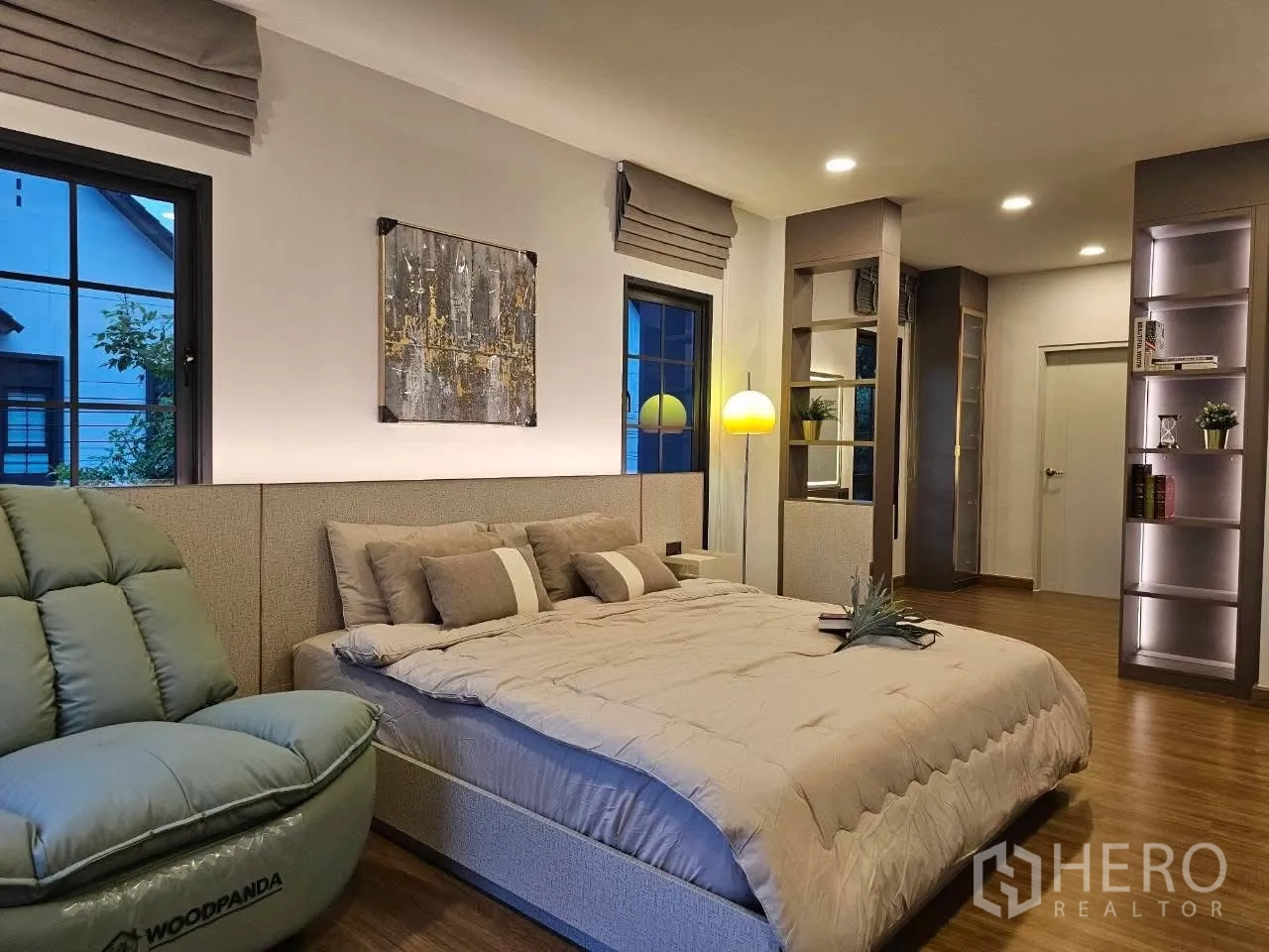 Detached House for rent or sale in Bang Phli, Samut Prakan - Stylish bedroom with artwork, large windows, and recliner chair.