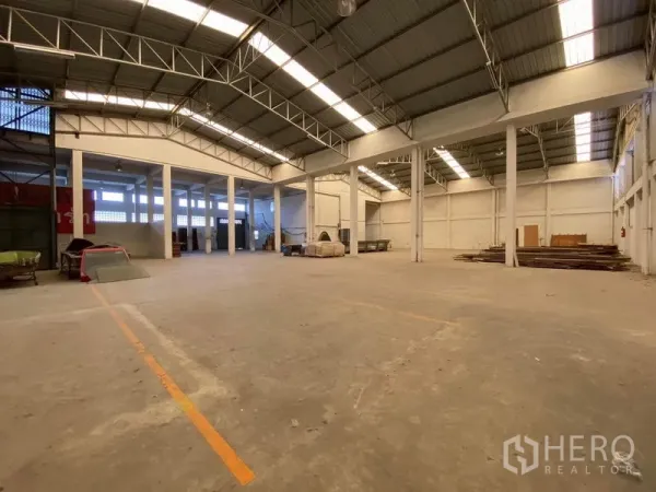 工厂 出售在Bang Phli, Samut Prakan - 高挑仓库大厅，钢桁架、天窗与划线作业区。