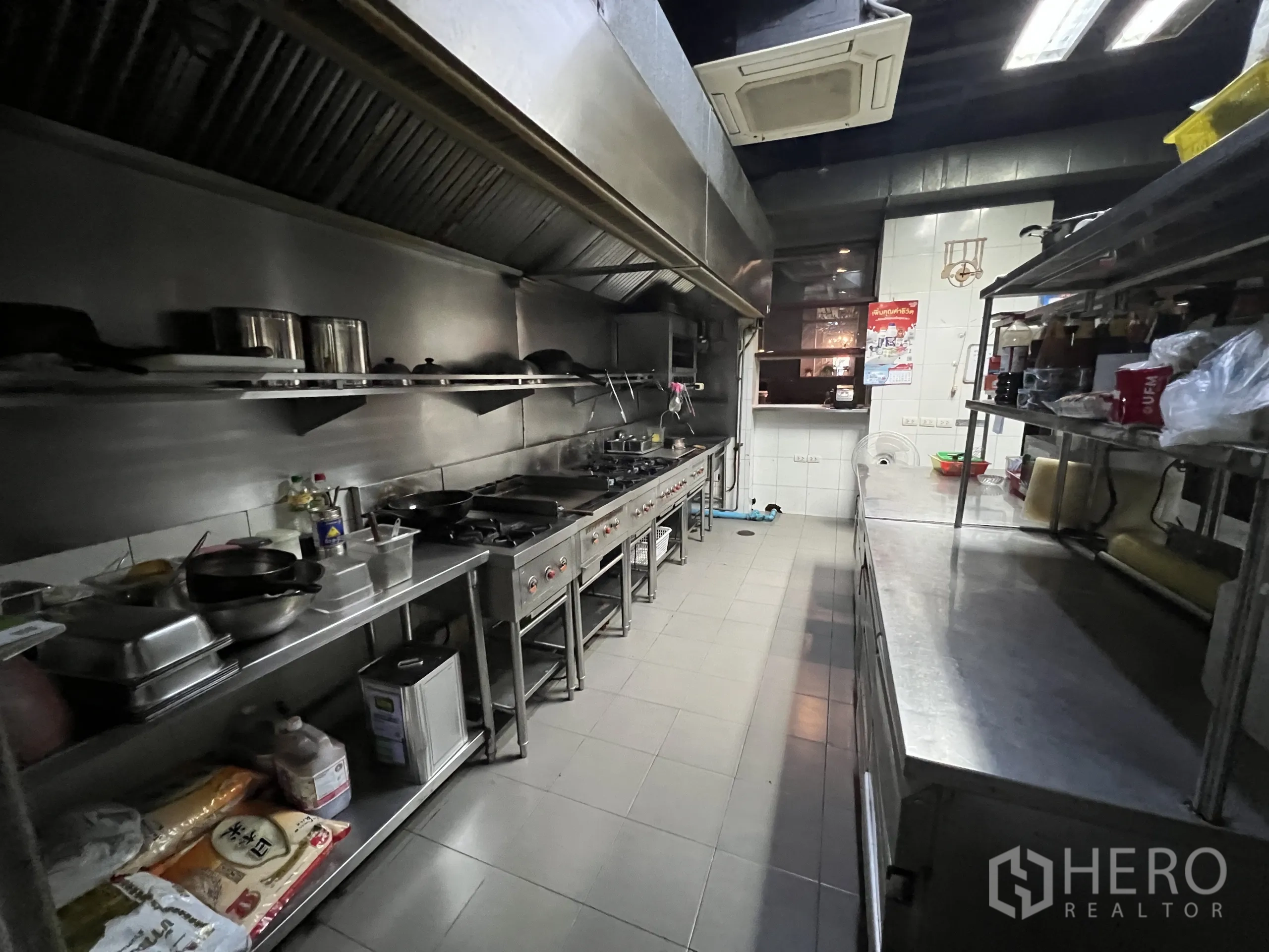 Retail Space for rent in Watthana, Bangkok - Line kitchen with long exhaust hood, multiple gas ranges, and prep counters.
