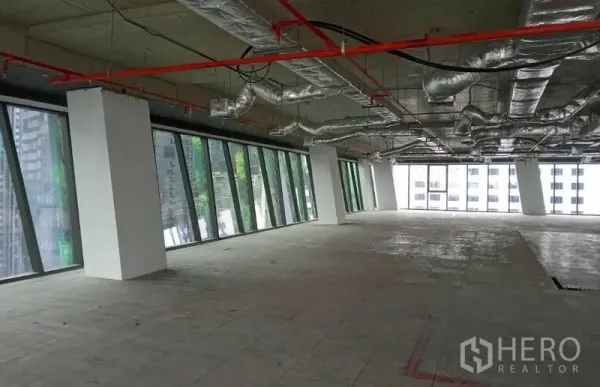 办公空间 出租 - 开放式角部办公区，长排倾斜落地玻璃与未完成的水泥地面