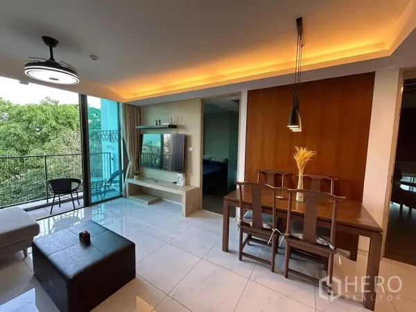 公寓 出租在Watthana, Bangkok - 餐区临阳台与电视墙，窗外可见绿树景观