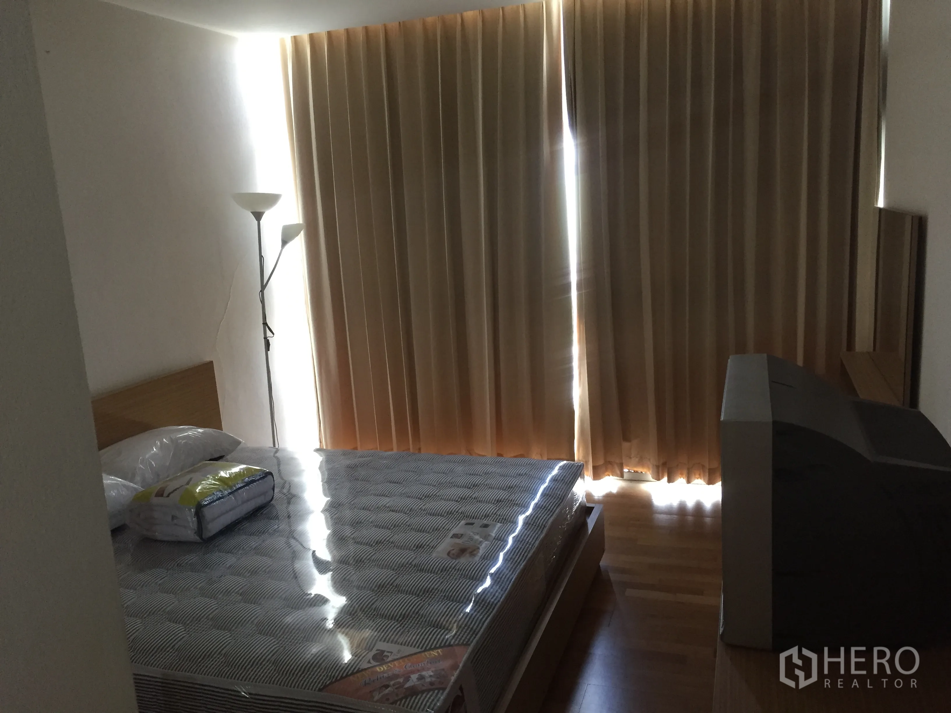 公寓 出租在Sathon, Bangkok - 卧室配遮光窗帘，床垫全新，落地灯与电视柜，木地板。