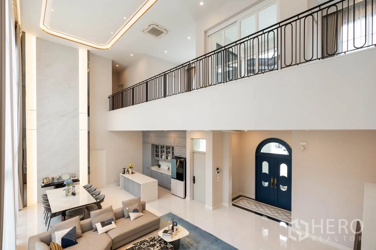 Detached House for rent or sale in Bang Kapi, Bangkok - Double-height living and dining area with mezzanine balcony and open kitchen.