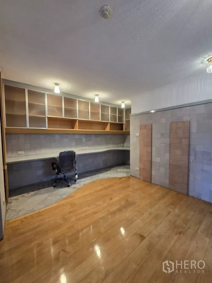 公寓 出租在Pathum Wan, Bangkok - 大型工作区/卧室，丰富置物架与木地板。