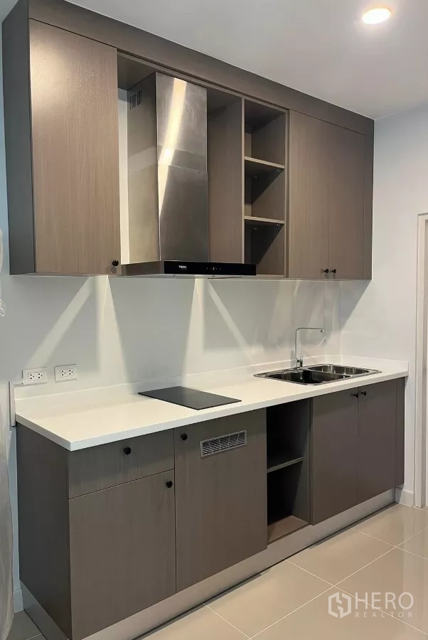 Detached House for rent or sale in Bang Phli, Samut Prakan - Full view of the fitted kitchen with ample storage cabinets and a long worktop.