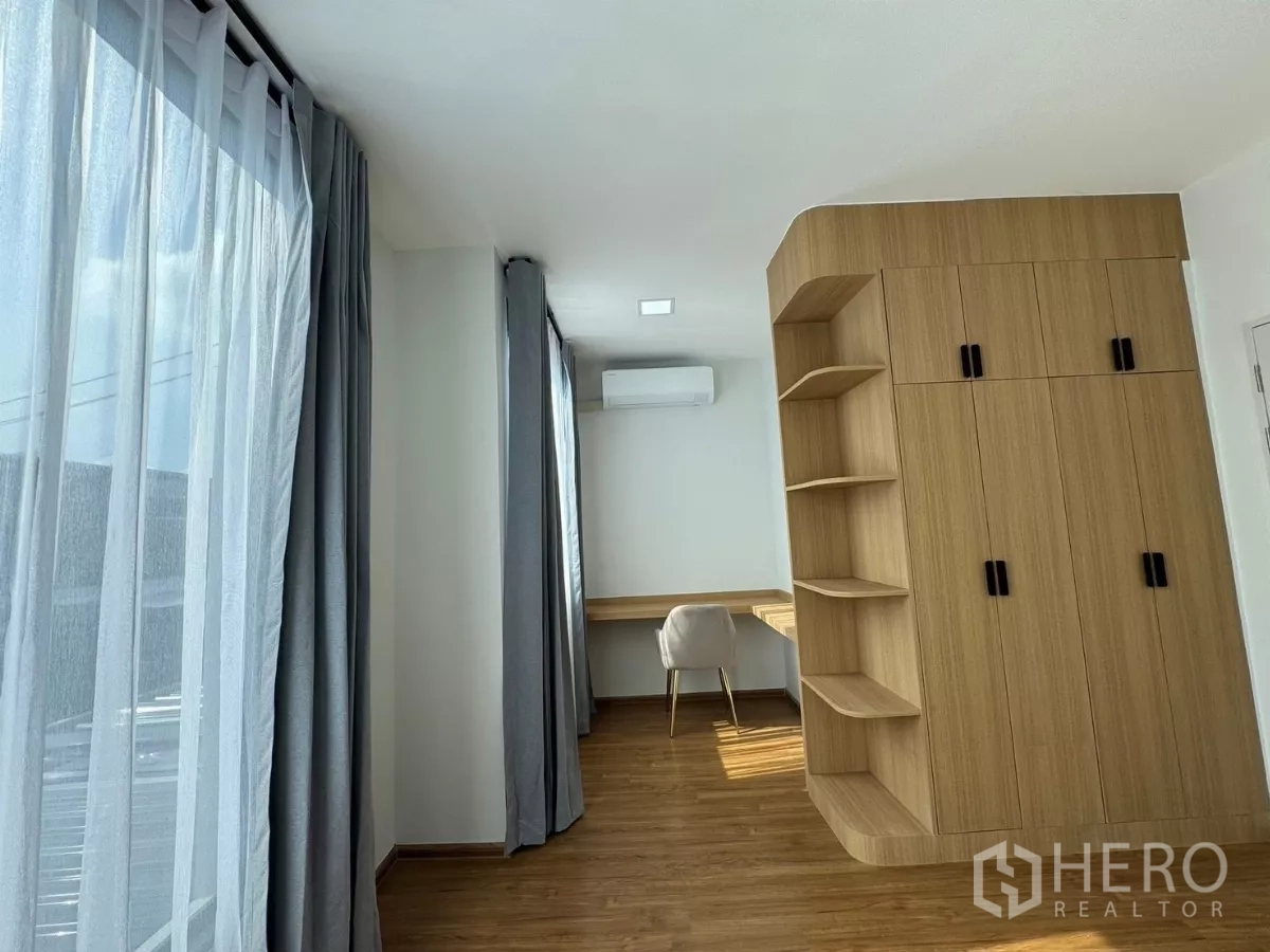 Townhouse for rent in Bang Phli, Samut Prakan - Long workspace with floor-to-ceiling windows and fitted cabinetry, ideal as a third bedroom.