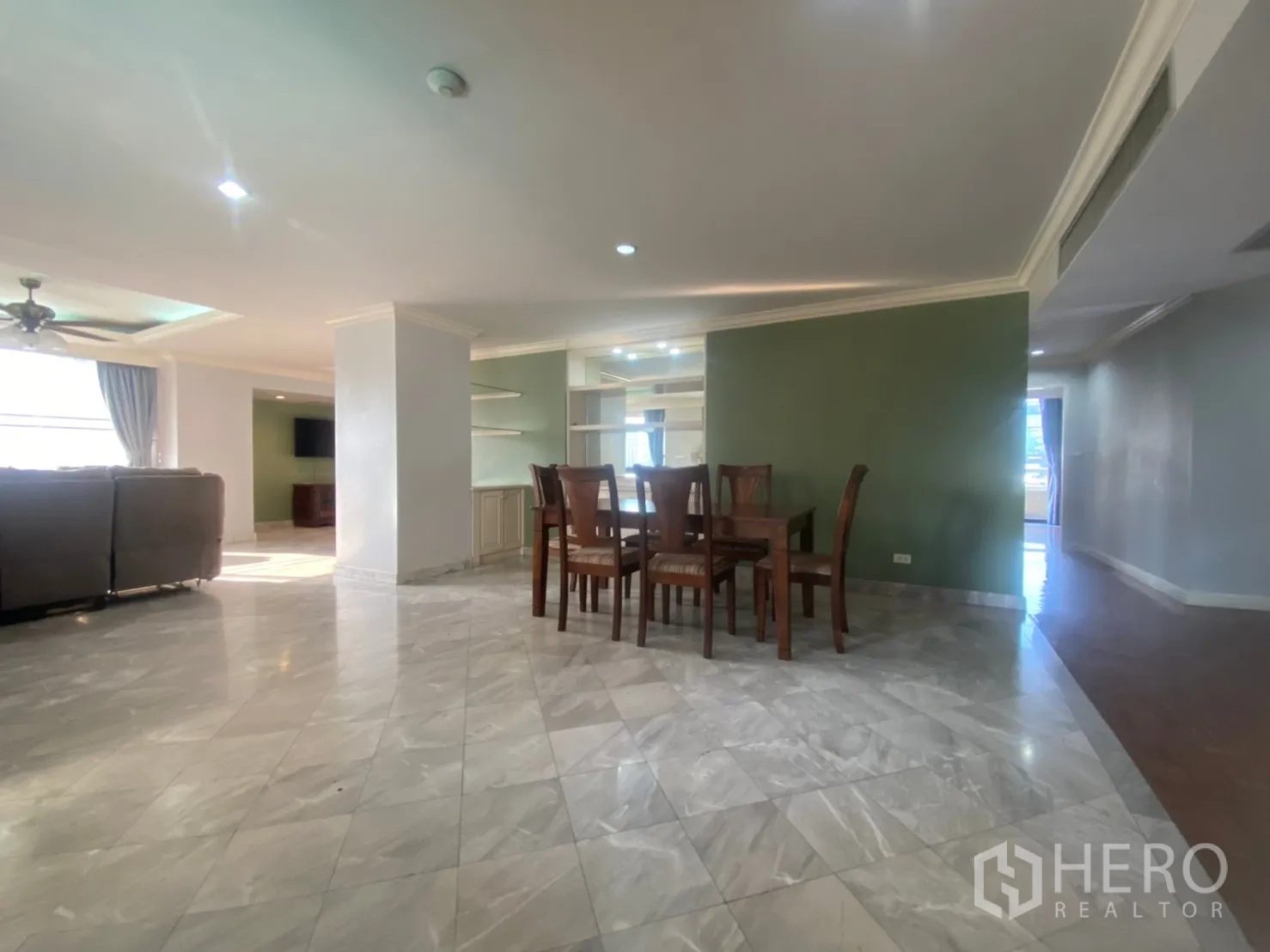 Condominium for rent or sale in Watthana, Bangkok - Dining zone with marble floors and a wooden dining set in an open-plan layout.