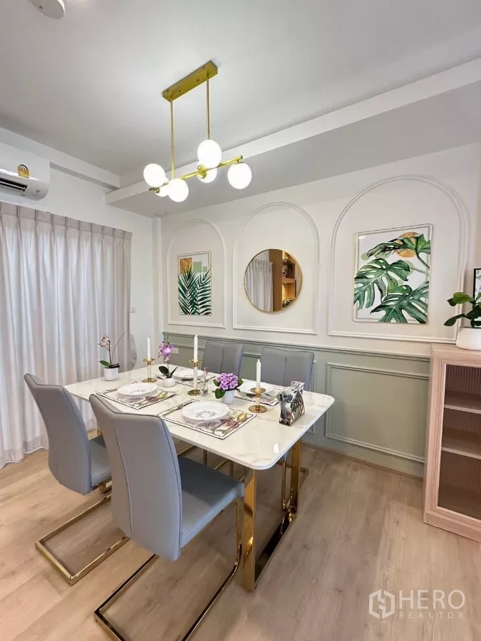 联排别墅 出租在Prawet, Bangkok - 用餐区，大理石餐桌、六把灰色椅、金色吊灯和墙面线条。