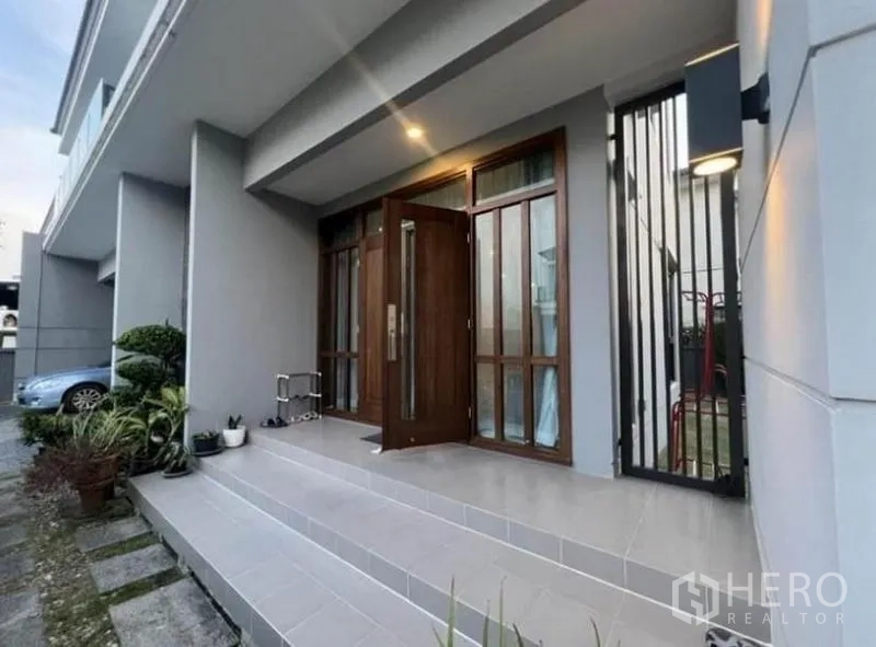 Detached House for rent - Entrance terrace with tiled steps, planters and a sturdy wooden door at dusk.
