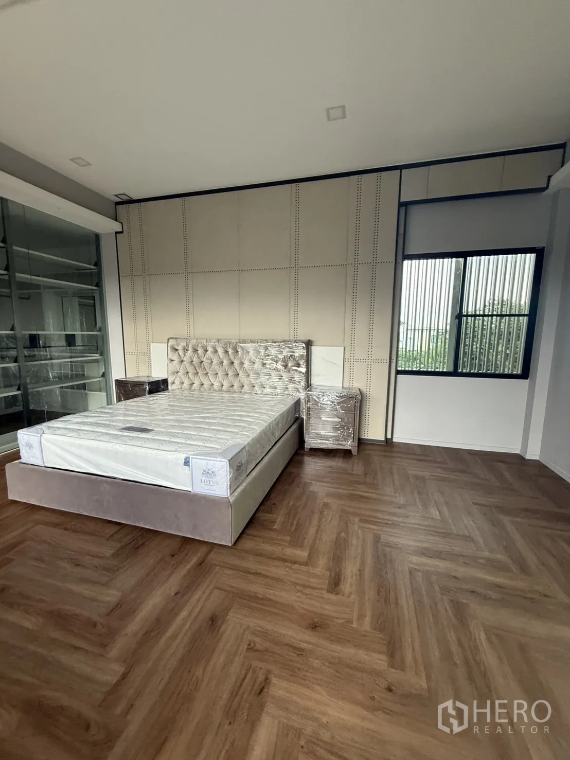 Detached House for rent in Saphan Sung, Bangkok - Bedroom featuring a tufted headboard, accent wall and glass shelving.