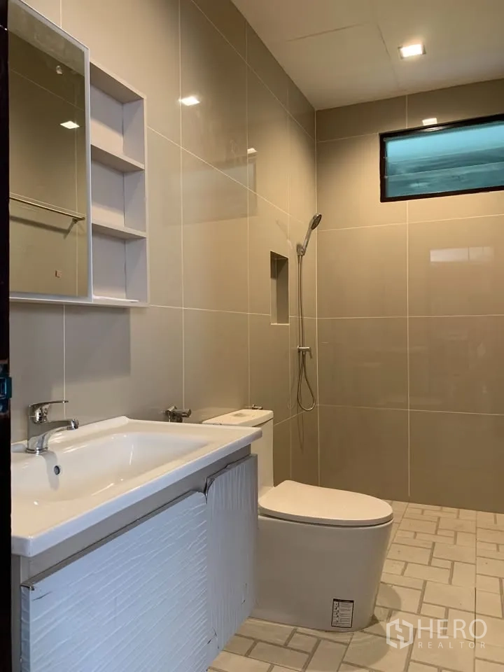 Detached House for rent in Phra Khanong, Bangkok - Modern tiled bathroom with vanity, toilet and open shower with niche.