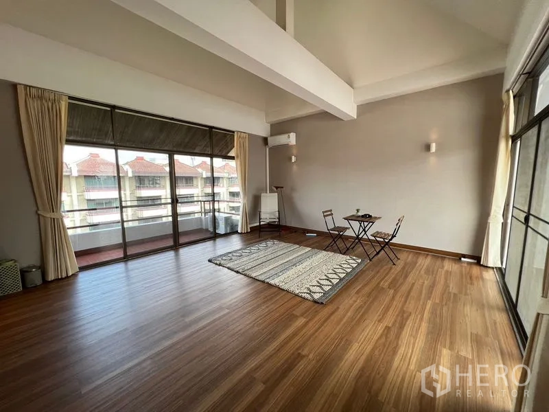 Townhouse for rent or sale in Suan Luang, Bangkok - Loft-like room opening to a long balcony with neighborhood views.