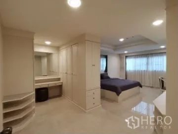 Apartment for rent in Watthana, Bangkok - Bedroom with extensive wardrobes, vanity area, shelving and glossy tiled floor.