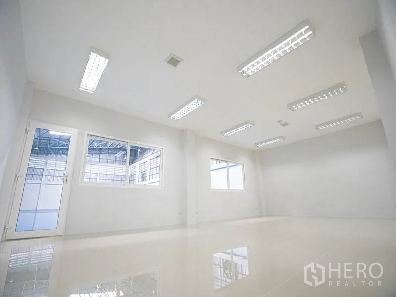 Factory for rent in Bang Bo, Samut Prakan - Bright white office room with tiled floor, fluorescent lighting and windows overlooking the production hall.