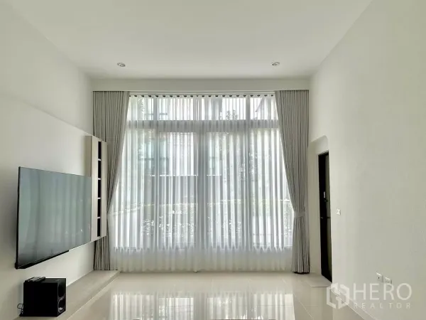 独立式住宅 出租或出售在Prawet, Bangkok - 极简客厅，3.6米高顶与亮面瓷砖地。