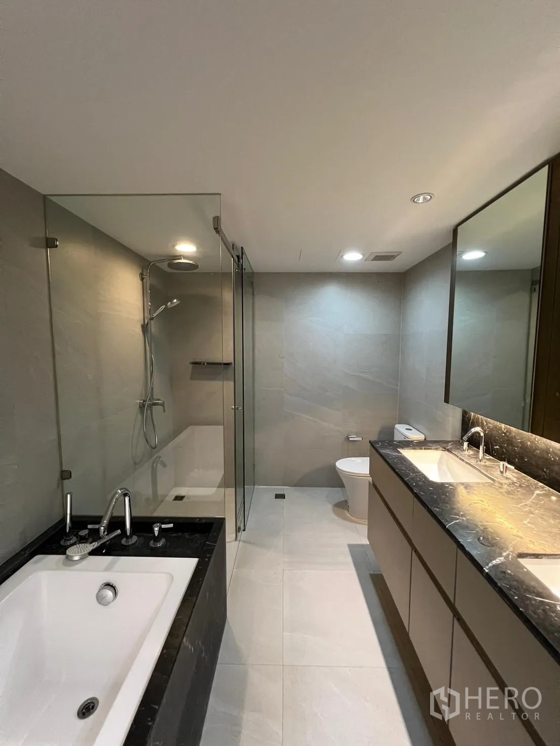 Condominium for rent or sale in Sathon, Bangkok - Modern bathroom with soaking tub, glass shower and double-sink vanity in a renovated condo.