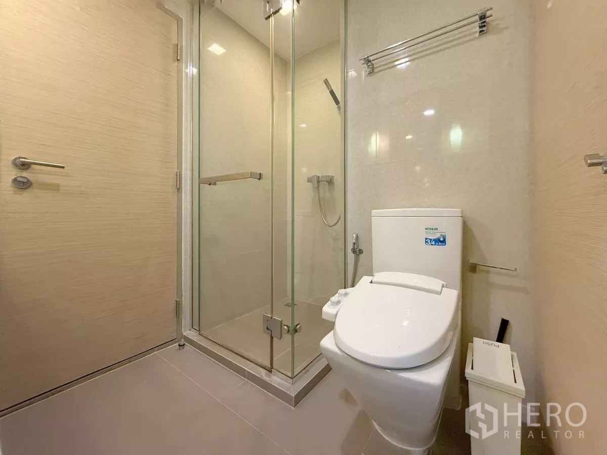 公寓 出租或出售在Watthana, Bangkok - 浴室配玻璃淋浴房与现代坐便器。