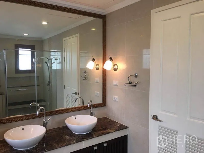 Detached House for rent in Bang Phli, Samut Prakan - Contemporary bathroom featuring double vessel sinks on a marble countertop and a glass shower enclosure.