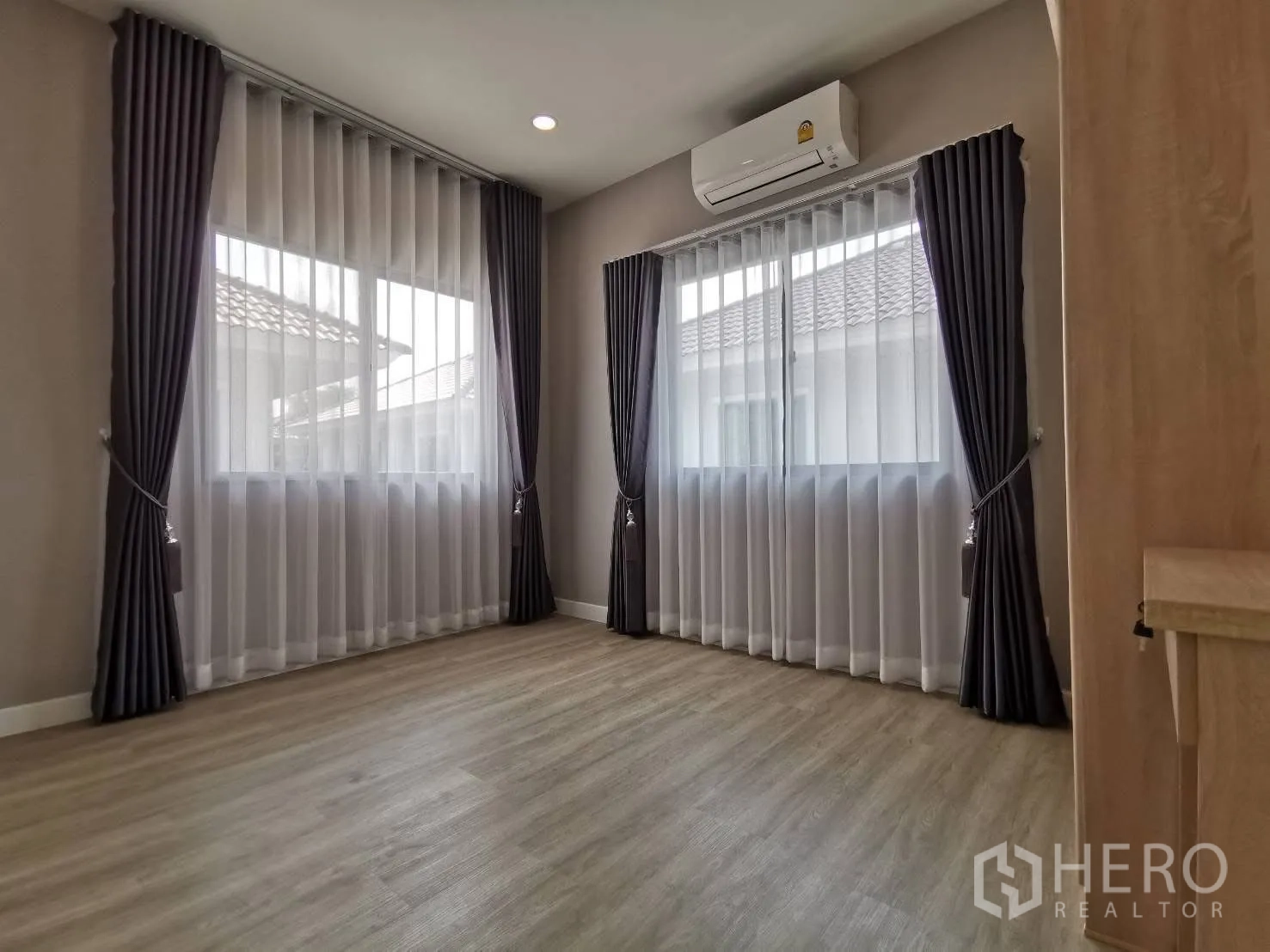 บ้านเดี่ยว for rent in Bang Phli, Samut Prakan - ห้องชั้นบนสว่าง มีหน้าต่างใหญ่สองบาน ผ้าม่านทึบและโปร่ง พื้นลามิเนต และแอร์ผนัง