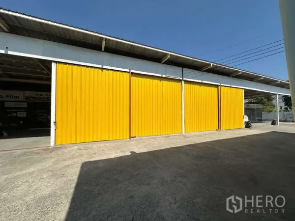 คลังสินค้า ให้เช่าในBang Khen, Bangkok - ประตูเลื่อนเหล็กสีเหลืองของโกดังพร้อมลานคอนกรีตกว้างในเขตบางเขน