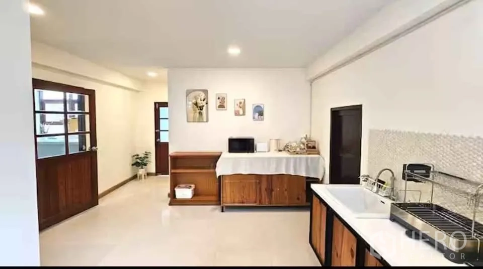 独立式住宅 出租在Khlong Toei, Bangkok - 厨房另一视角，通往室外的门与木柜。