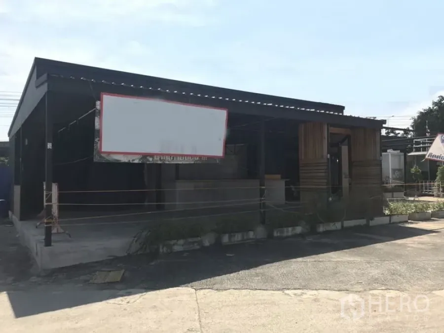 Retail Space for rent in Khlong Toei, Bangkok - Single-storey retail unit with steel roof, blank signboard frame and open forecourt near Phra Khanong.