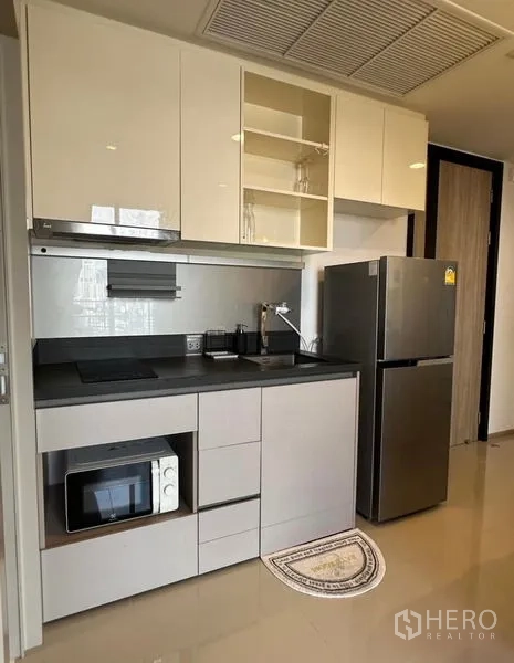 Condominium for rent - Compact linear kitchen with induction hob, microwave and stainless refrigerator.