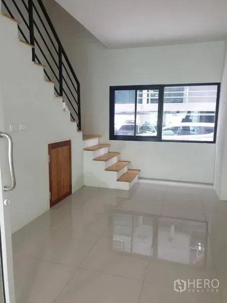 Home Office for rent in Bang Rak, Bangkok - Entry hall with a wooden staircase, metal railing, window, and under-stair storage.