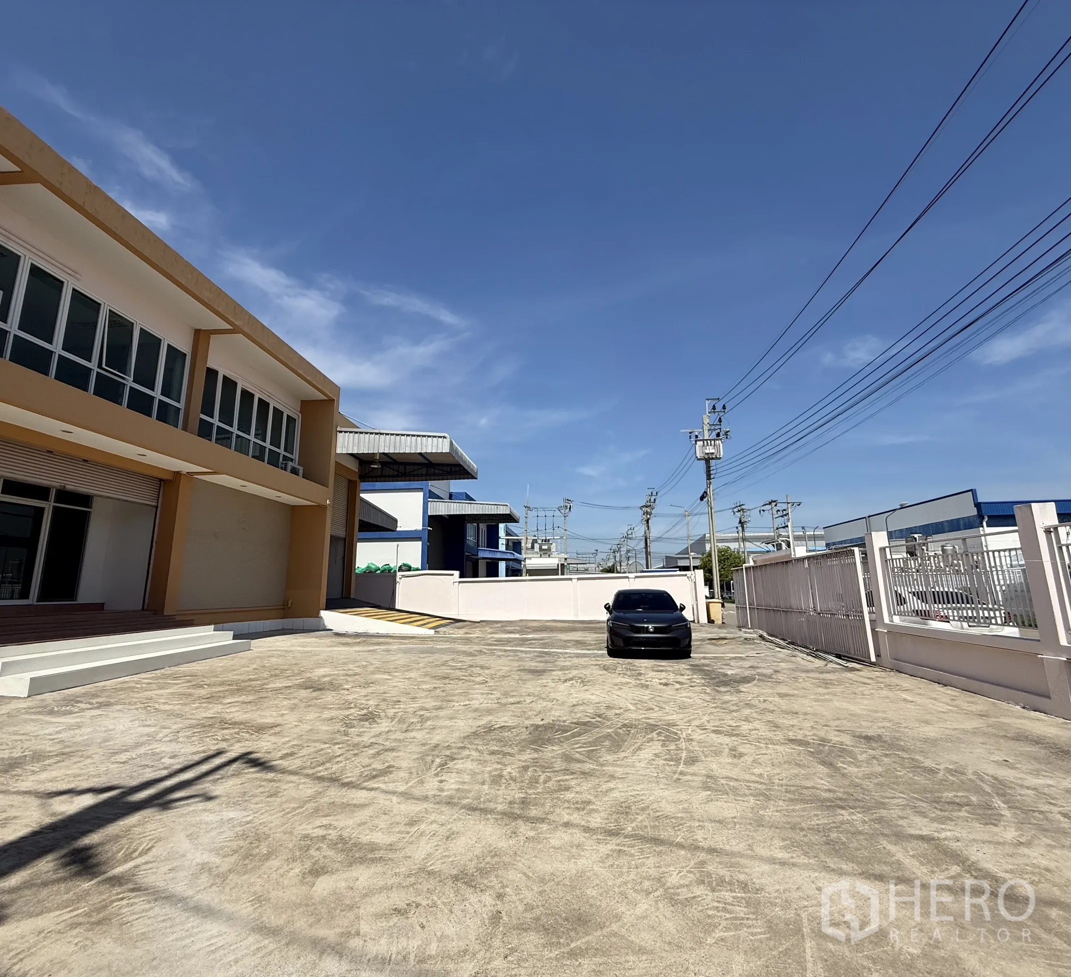 Warehouse for rent or sale in Bang Bo, Samut Prakan - Gated concrete forecourt with two‑storey office and warehouse building, ample driveway for trucks.