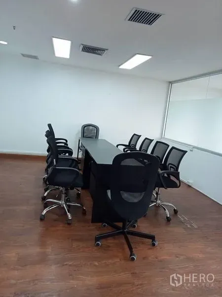 办公空间 出租在Ratchathewi, Bangkok - 会议室，长桌与网布椅，木地板、白色墙面。