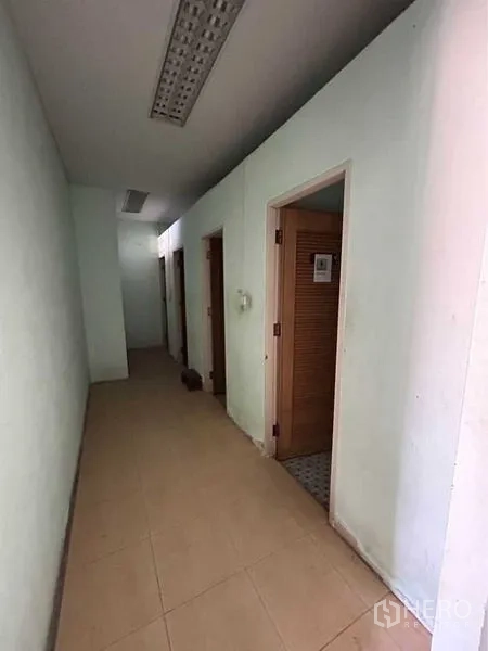 货栈 出租在Sam Phran, Nakhon Pathom - 办公楼走廊，设有多间卫生间与功能房。
