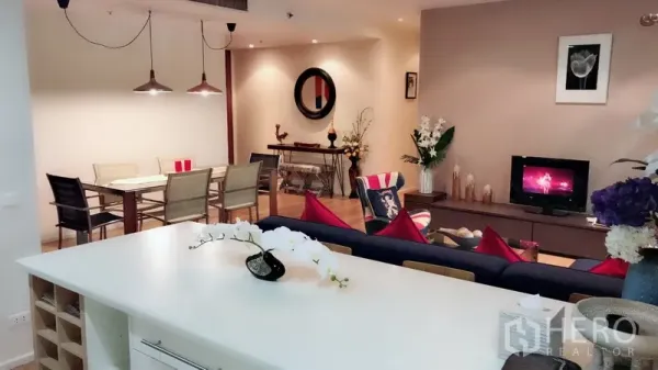 Condominium for rent in Bang Rak, Bangkok - Kitchen island overlooking lounge and dining space with warm lighting and contemporary decor.