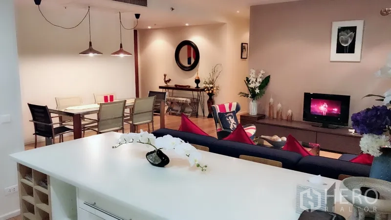 Condominium for rent in Bang Rak, Bangkok - Kitchen island overlooking lounge and dining space with warm lighting and contemporary decor.