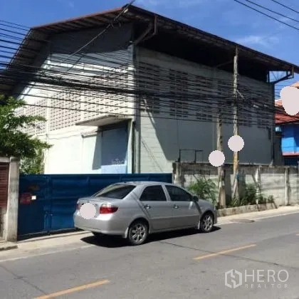 Warehouse for rent in Mueang Nonthaburi, Nonthaburi - Street-facing warehouse exterior with blue sliding gate, concrete walls and metal roof in urban Nonthaburi.