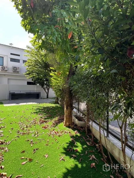 独立式住宅 出租或出售在Bang Phli, Samut Prakan - 房屋一侧的花园草坪，成树与绿篱提供良好私密性。