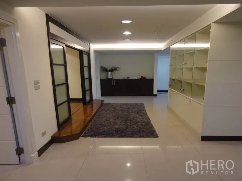 Condominium for rent in Watthana, Bangkok - Hallway with built-in display shelves, rug and recessed ceiling lights.