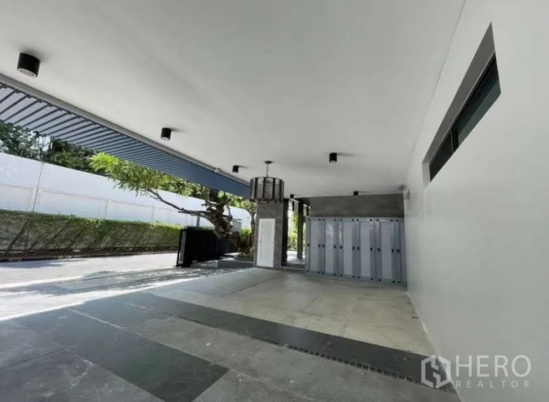 Detached House for sale in Khlong Toei, Bangkok - Covered parking area with ceiling lights and gate access.