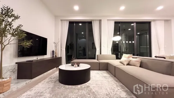 Detached House for rent in Saphan Sung, Bangkok - Contemporary living room with sectional sofa, TV wall and large sliding doors.