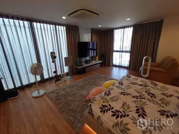 联排别墅 出售在Lat Phrao, Bangkok - 主套房设大窗、电视柜与温暖木地板。