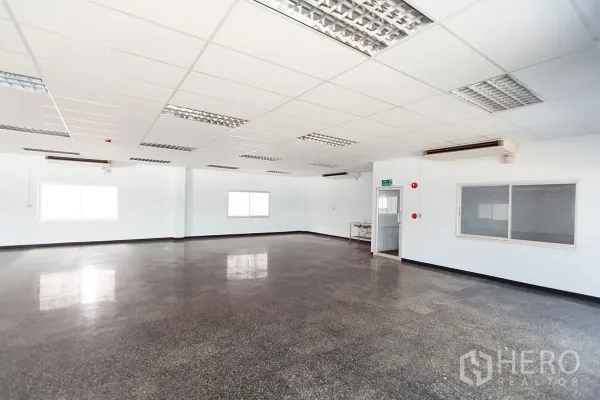 Factory for rent in Si Racha, Chon Buri - Spacious office or workspace with drop ceiling, fluorescent lighting, and windows.