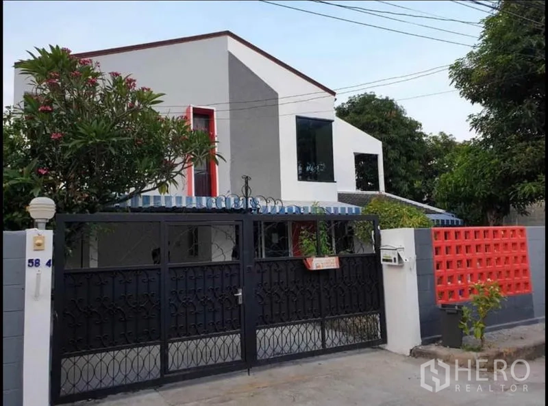 独立式住宅 出租在Lat Phrao, Bangkok - 临街立面，黑色金属大门、私密围墙与现代两层外观。