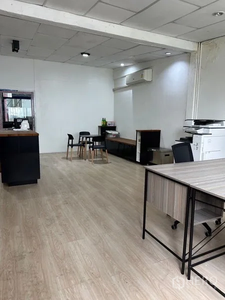 Shophouse for rent in Khlong Toei, Bangkok - Open-plan shophouse office with light wood floors, drop ceiling, desks and copier near the entrance.