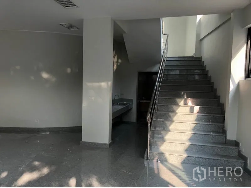 Office Space for rent in Khlong Toei, Bangkok - Internal staircase with stainless-steel handrail and a sink area adjacent to restrooms.