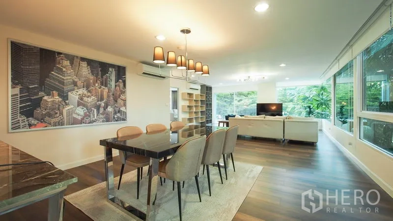 Condominium for rent in Khlong San, Bangkok - Open-plan living and dining room with wood floors, large windows, and a modern chandelier.