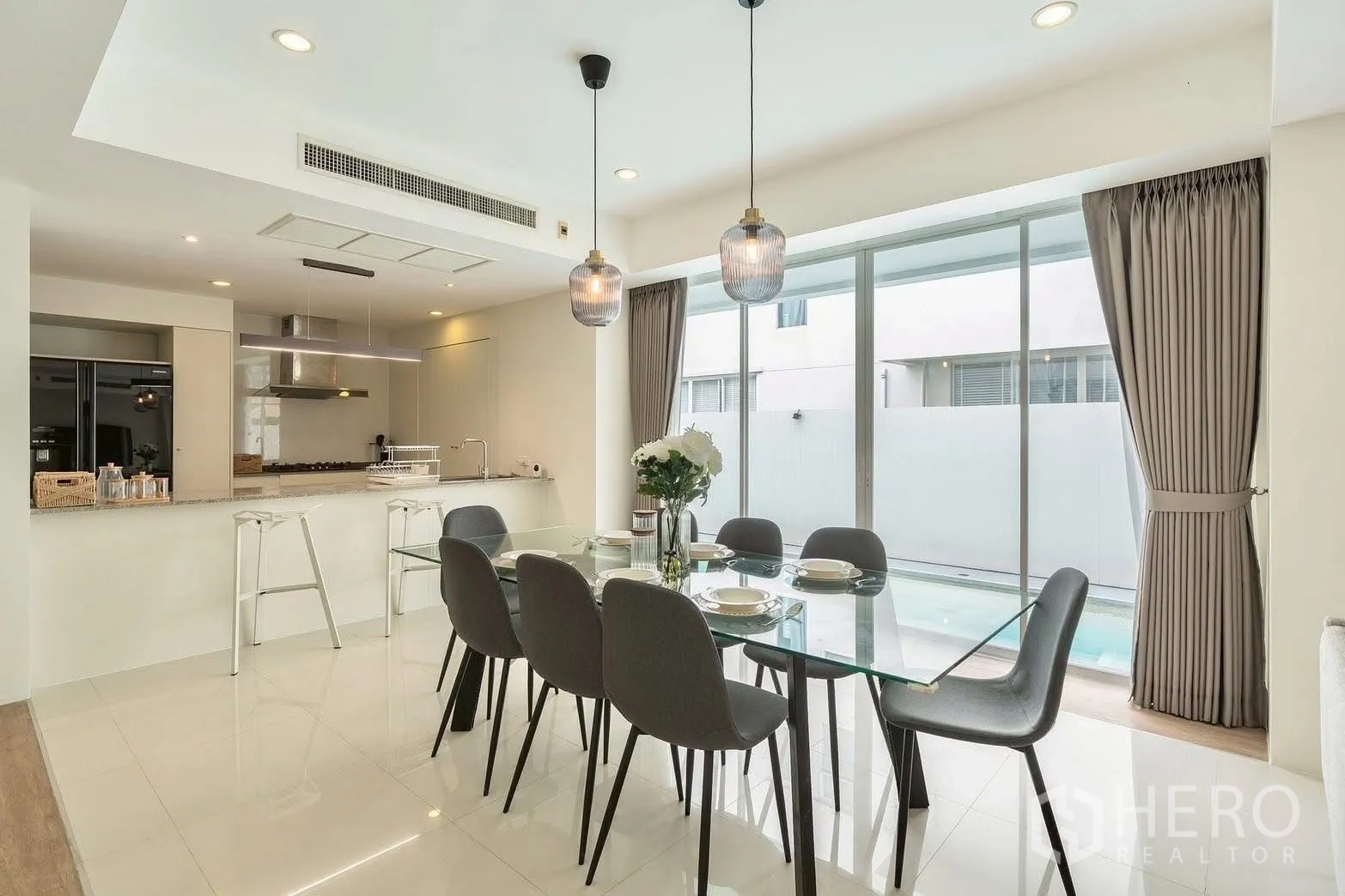 Detached House for rent in Saphan Sung, Bangkok - Dining area with glass table for six next to the kitchen island.