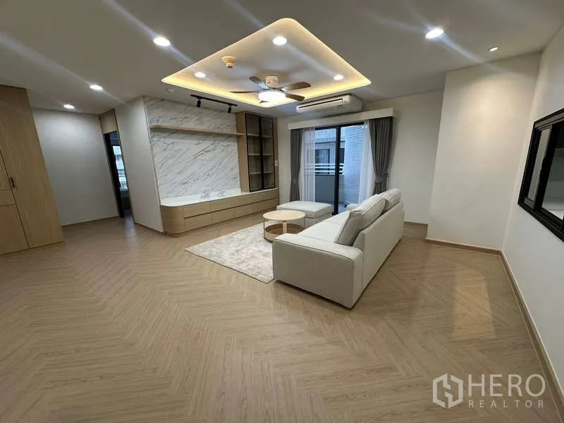 公寓 出租在Watthana, Bangkok - 客厅设L型沙发、大理石电视墙与灯槽吊顶
