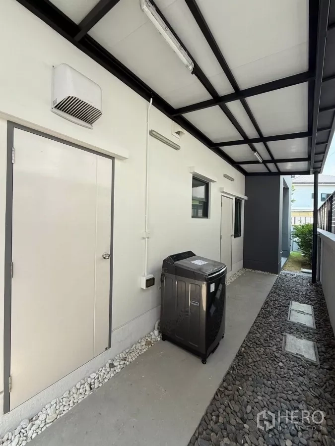 独立式住宅 出租在Bang Phli, Samut Prakan - 侧面服务走廊，遮雨顶棚、洗衣区与储物间