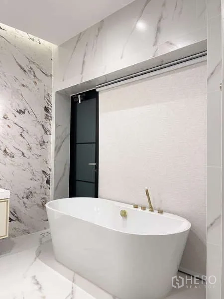 Detached House for rent in Saphan Sung, Bangkok - Contemporary bathroom with a freestanding bathtub and marble walls.